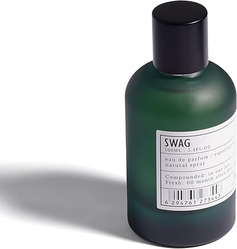 Green perfume bottle with black cap and white label on a white background